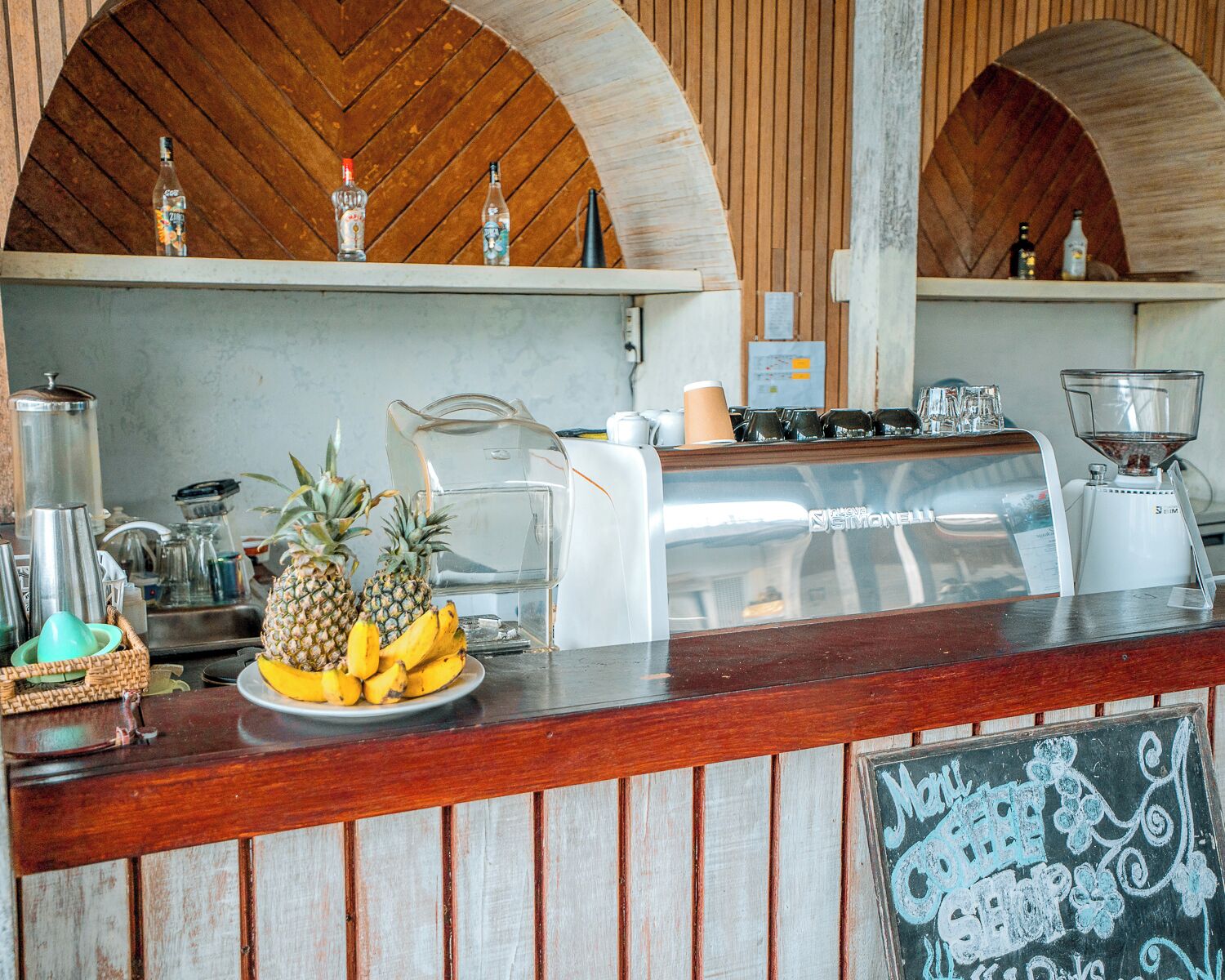 A bar area with a wooden counter, a chalkboard menu, and various bar tools.