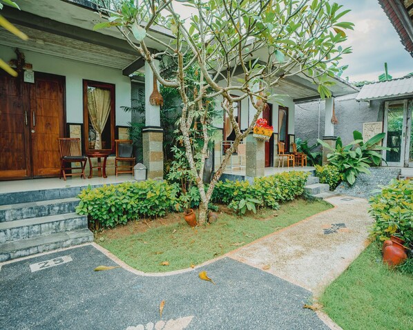 Una casa con porche, mobiliario de exterior y jardín.