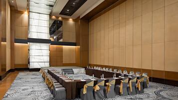 Un salón de conferencias con una larga mesa, sillas y piso alfombrado.