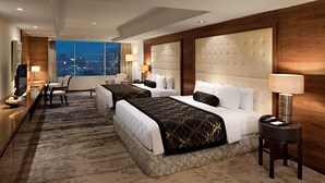 A hotel room with two beds, a desk, and a view of the city. - Aryaduta Medan (Medan)