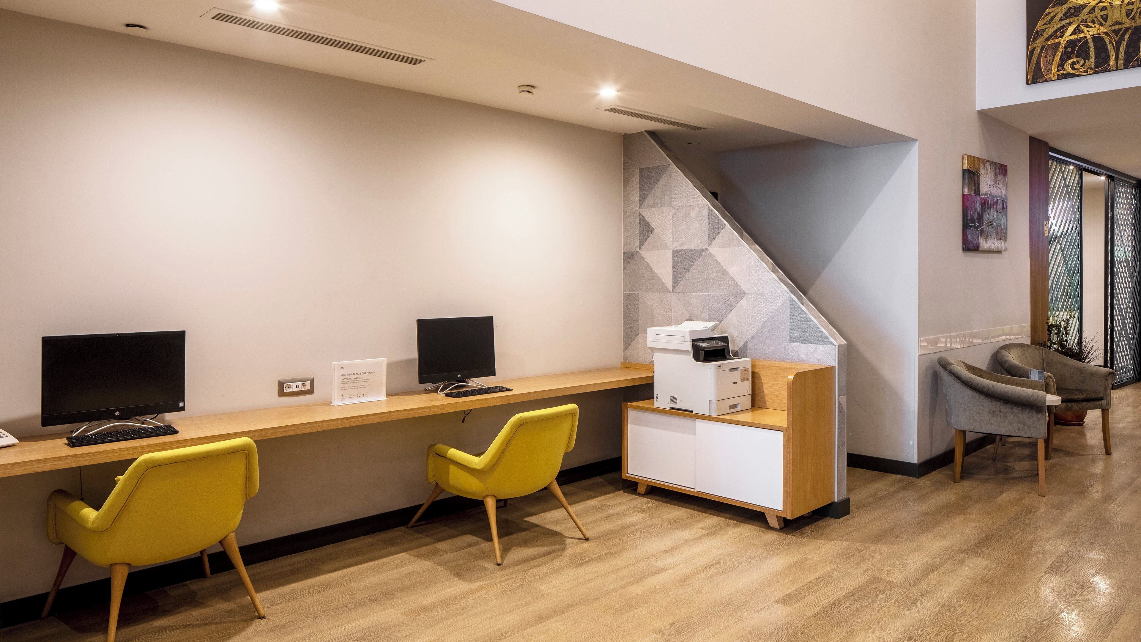 A modern office space with two desks, computers, and chairs.