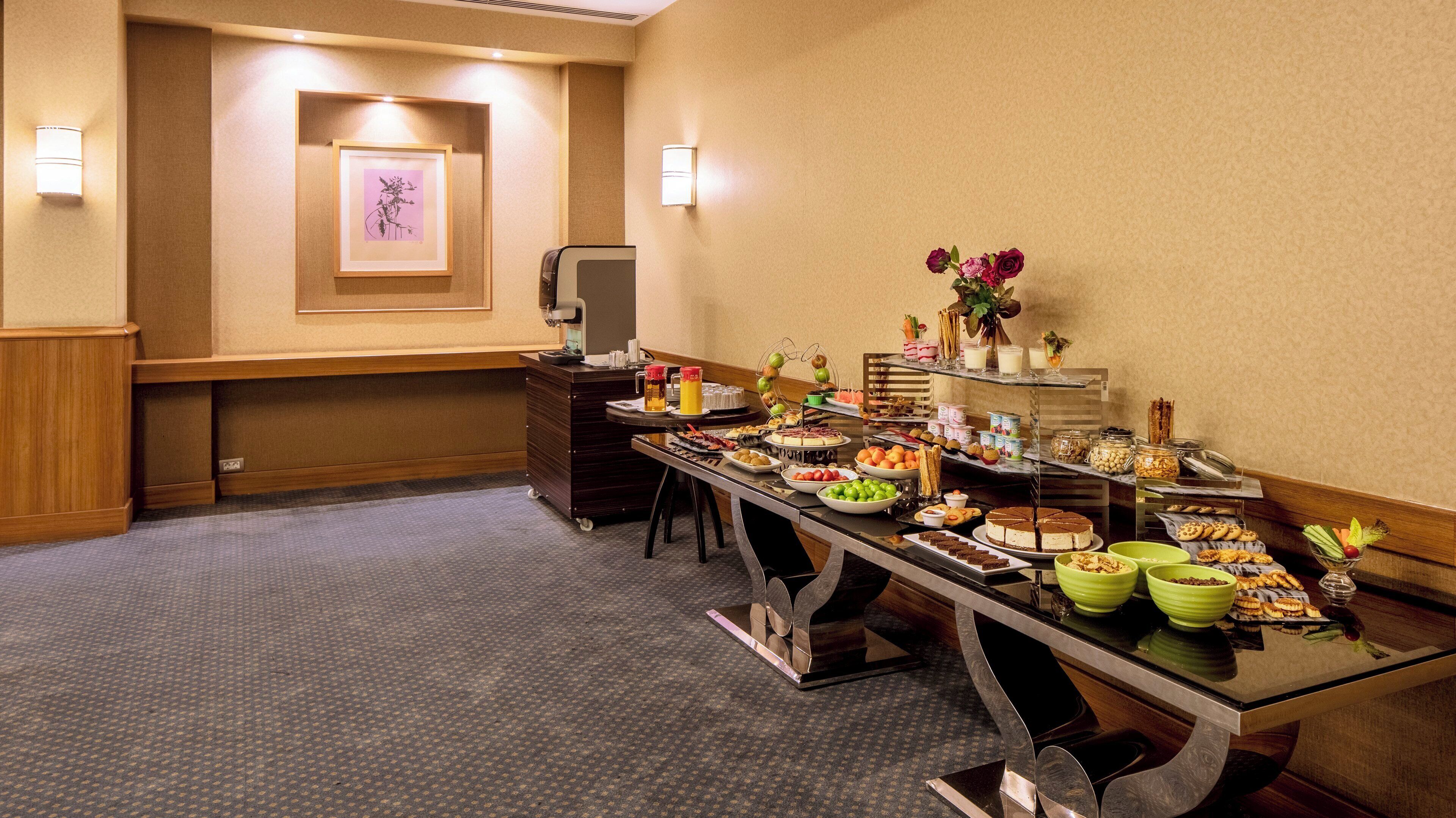 Un buffet proposant une variété de plats, avec un téléviseur en arrière-plan.