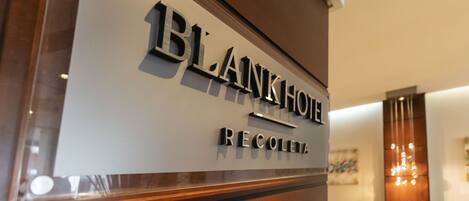 A sign for 'BLANKHOF RECOLETA' with a modern design and a wooden frame.
