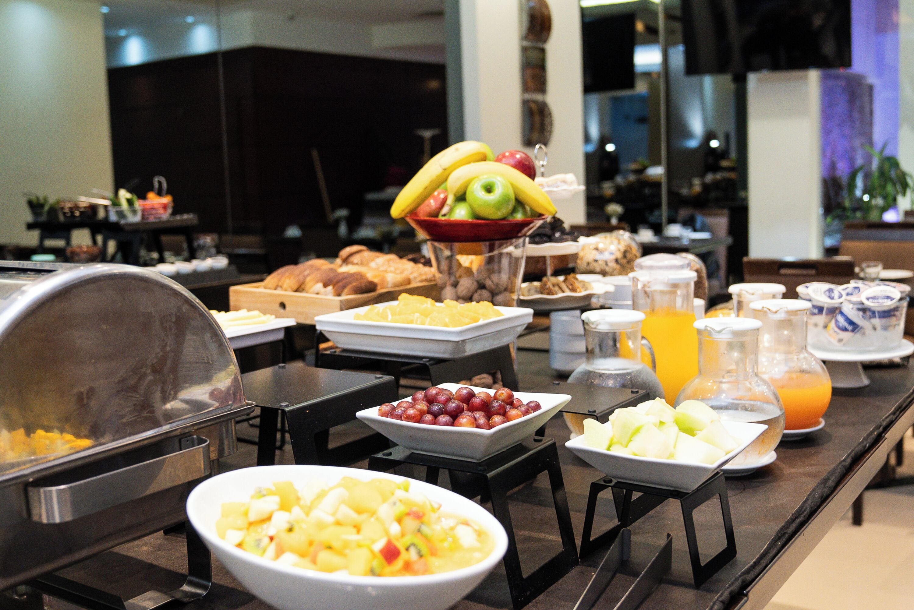 Ein Buffet mit verschiedenen Speisen, darunter Obst, Gebäck und Getränke.