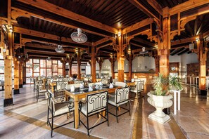 A spacious indoor dining area with wooden beams, tables set for dining, and a large potted plant. - SUNRISE Royal Makadi Resort - All inclusive (Makadi Bay)
