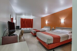 A hotel room with two beds, a desk with a computer, a chair, and a window with red curtains. - Motel 6 Pasadena, TX (Pasadena)