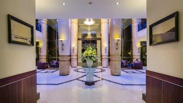 A spacious lobby with a central floral arrangement, large columns, and seating areas. - Sai Gon Quang Binh Hotel (Dong Hoi)