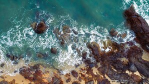 An aerial view of a rocky coastline with waves crashing against the shore. - Sai Gon Quang Binh Hotel (Dong Hoi)