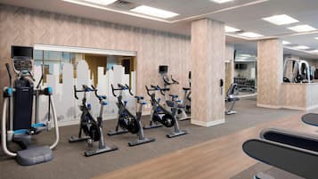 Un gimnasio con bicicletas estáticas, elípticas y máquinas de pesas.