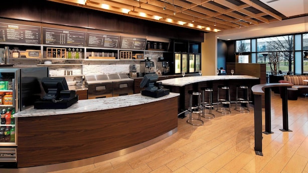 Eine moderne Bar mit einer Holztheke, Barhocker und einer Speisekarte.