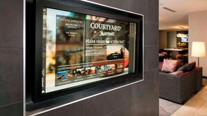 Ein digitales Display, das die Annehmlichkeiten und Neuerungen des Courtyard Marriott bewirbt.