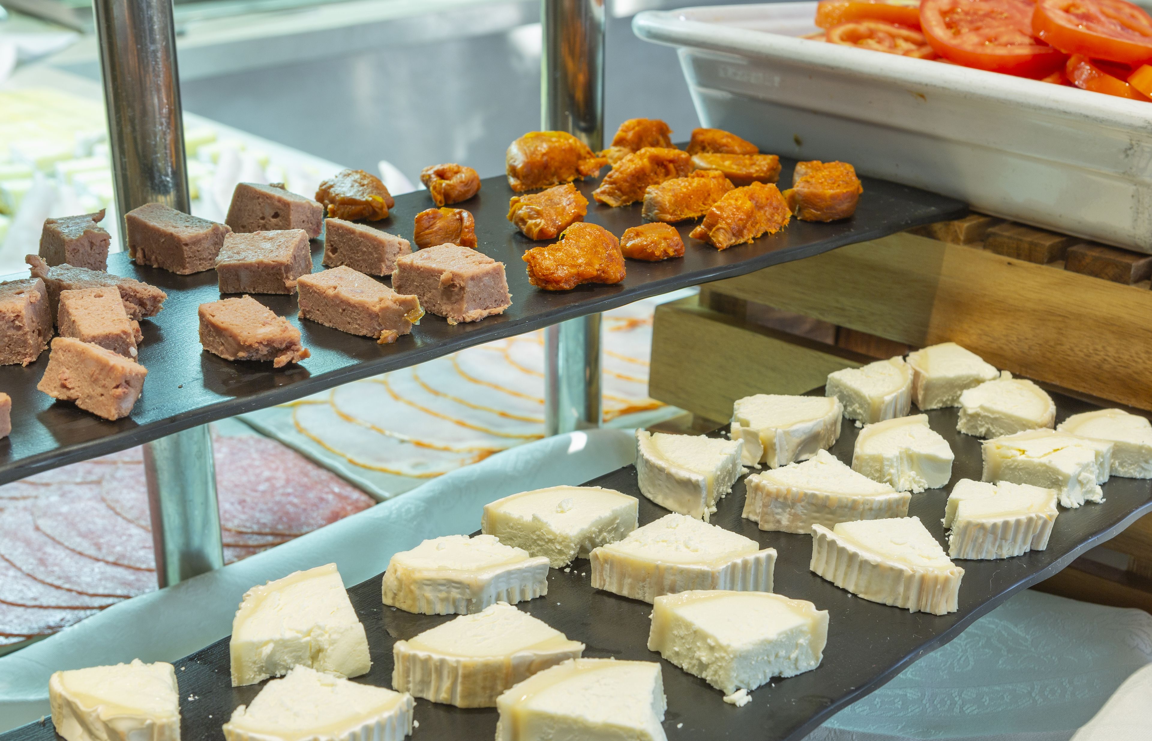 Un buffet con diversi cibi, tra cui cubetti di carne e formaggio.