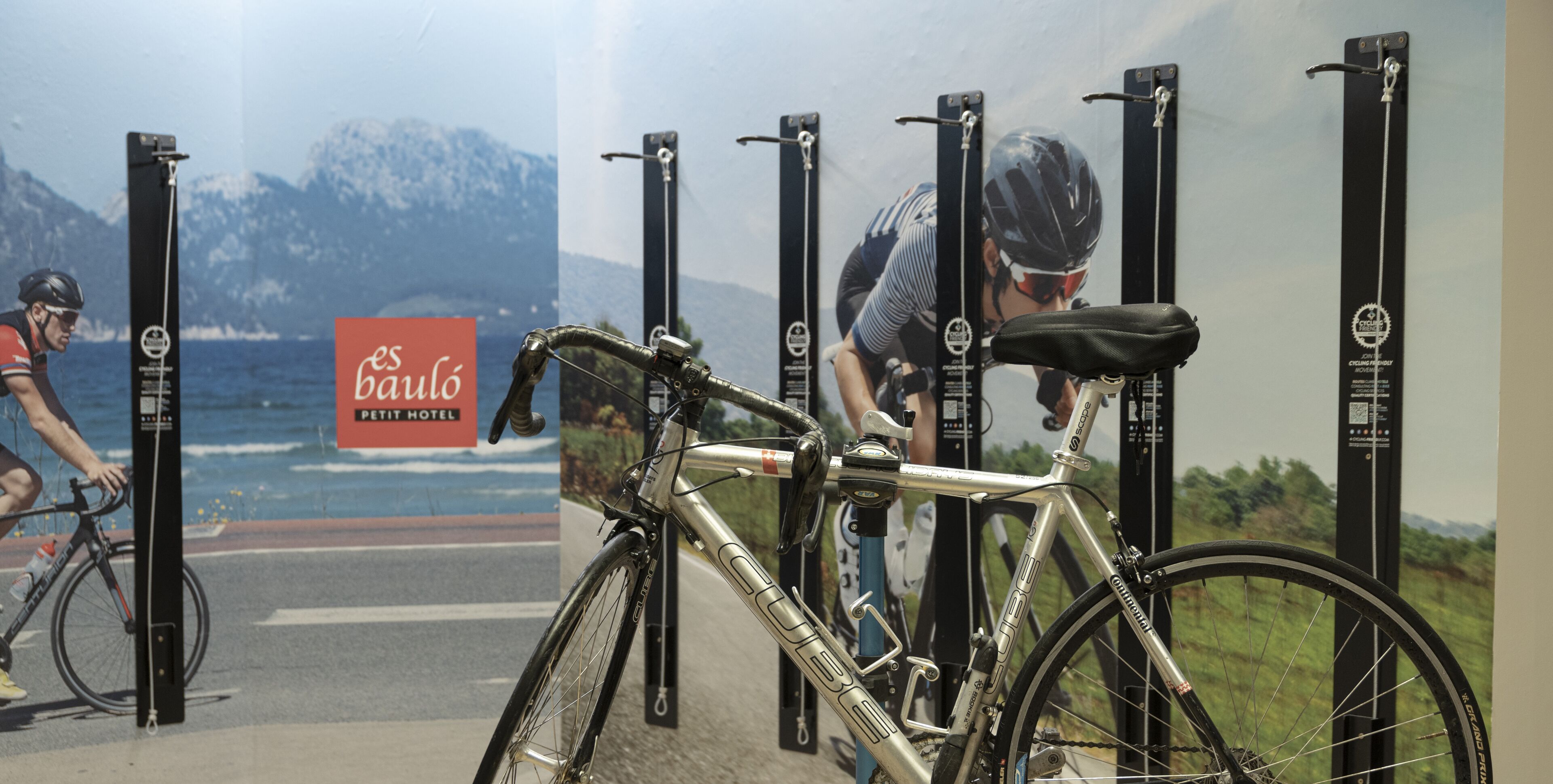 Una bicicleta estacionada frente a un muro con un letrero que dice "Baulo Pet Hotel".