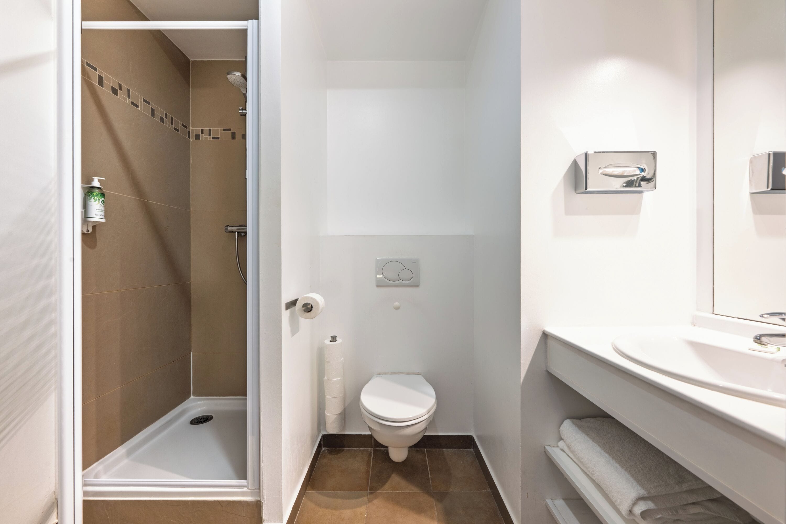 A bathroom with a shower, toilet, and sink.