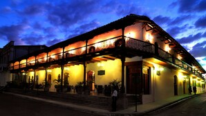 A historic building with a balcony and outdoor seating area, featuring a traditional architectural style. - Hotel Plaza Colon (Granada)