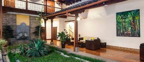 A traditional building with a covered patio, a stone sculpture, and a painting of a forest.