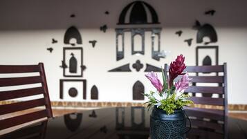 Ein Essbereich mit Tisch, Stühlen und einer Blumenvase.