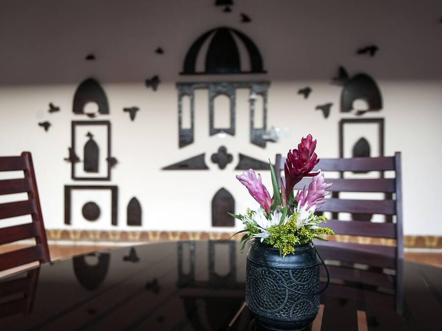 Ein Essbereich mit Tisch, Stühlen und einer Blumenvase.