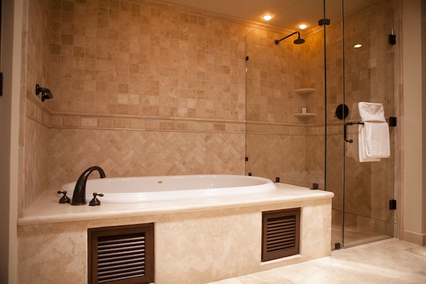 A modern bathroom with a freestanding bathtub, a glass shower enclosure, and a towel rack.