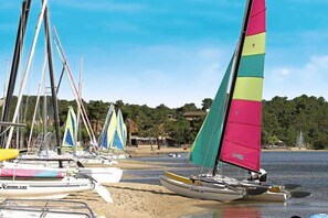 A beach with several sailboats docked along the shore. - Sowell LES Sentes (Carcans)