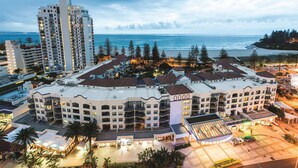 A hotel with multiple floors, a central courtyard, and a view of the ocean.