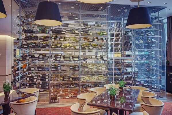 A wine cellar with numerous wine racks and a seating area with chairs and tables. - Grand Hotel River Park, a Luxury Collection Hotel Bratislava (Bratislava)