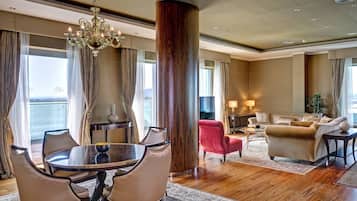 A spacious living room with a large wooden column, a chandelier, and a view of the outdoors.
