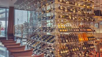 A wine cellar with numerous wine racks and a few chairs.