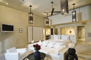 A modern hotel room with a large bed, white furniture, a TV, and decorative lighting. - Hôtel Dar Sabra (Marrakech)