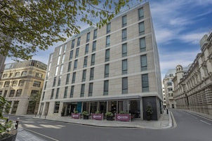 Ein modernes Hotel mit einer symmetrischen Fassade, großen Fenstern und einem Flachdach.