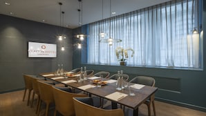 Een vergaderruimte met een lange tafel, stoelen en een bord met daarop Clayton Hotel London Wall.