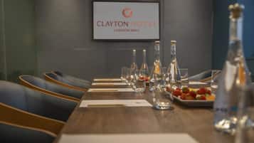 A conference table with empty chairs, glassware, and a plate of strawberries at Clayton Hotel, London Wall.
