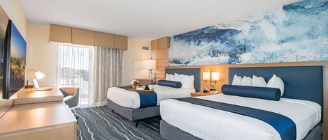 A hotel room with two beds, a desk, a TV, and a large painting on the wall.
