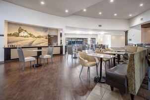 Un comedor espacioso con mesas y sillas altas, un gran mural en la pared y una decoración interior moderna.