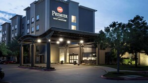 A hotel with a modern facade, a prominent sign reading "Premier Best Western," and a covered entrance area.
