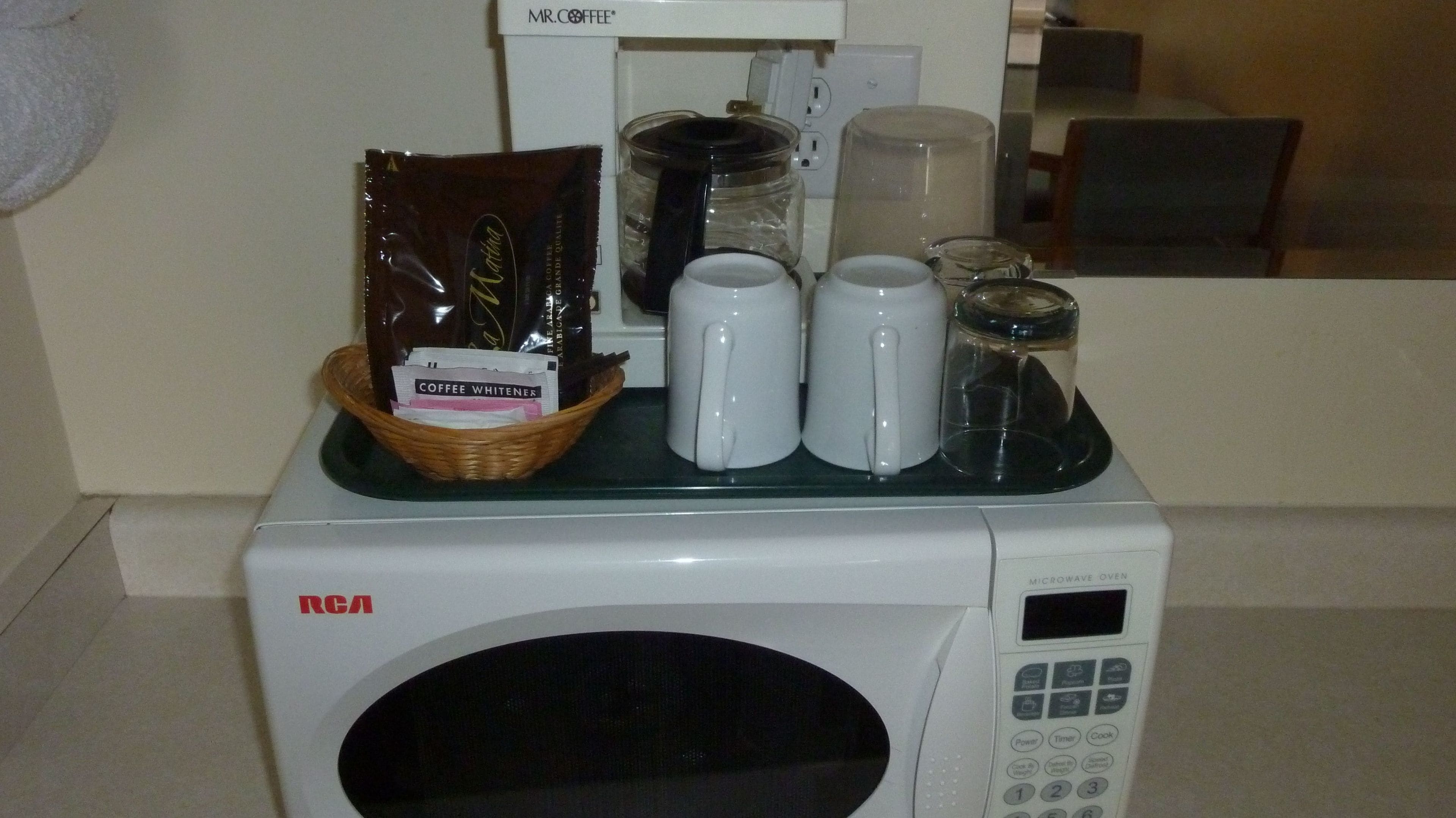 Un four à micro-ondes contenant un panier avec un sachet de café et un produit pour adoucir le café.