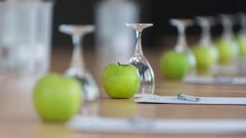 A table with green apples and clear wine glasses.