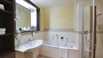 Une salle de bain moderne équipée d’une baignoire, d’une douche et d’un lavabo.