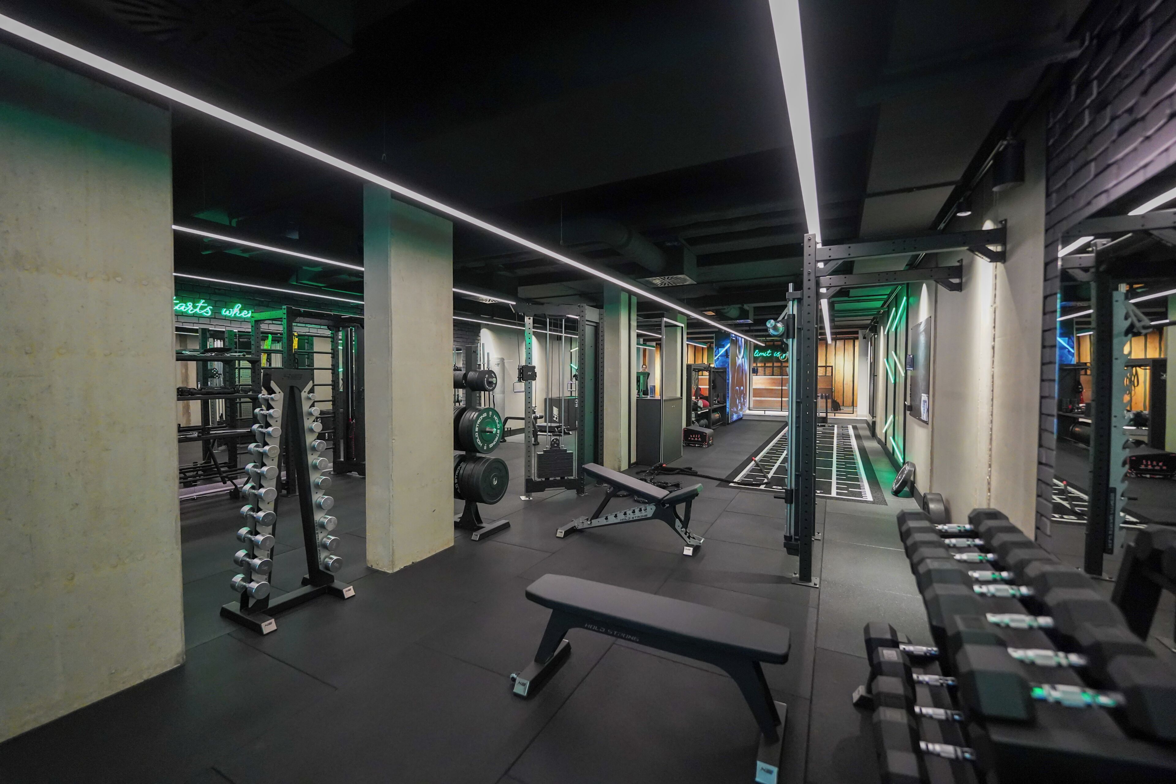 A gym with weightlifting equipment, benches, and a treadmill.