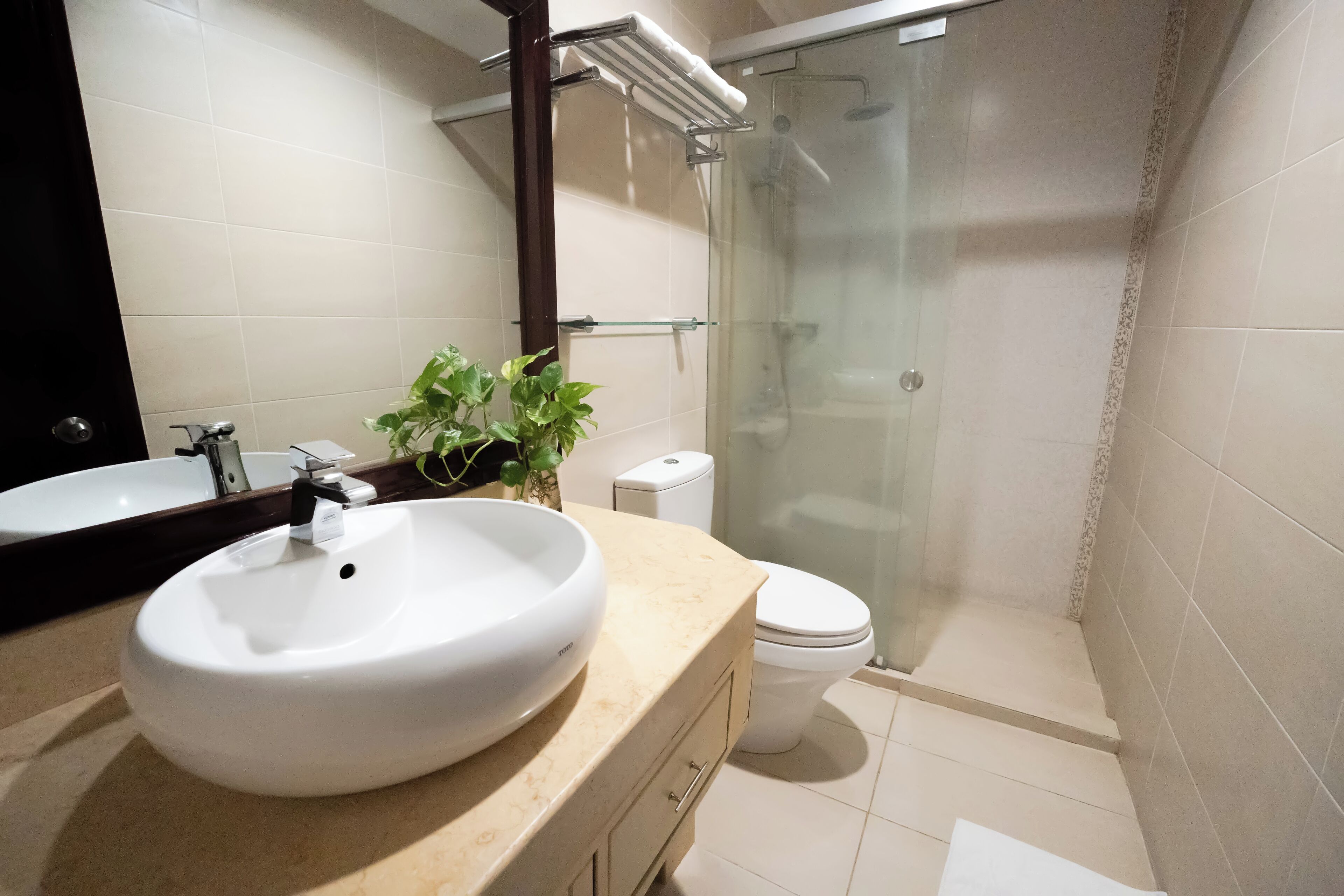 A bathroom with a white sink, a toilet, and a glass shower enclosure.