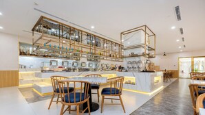 Um restaurante moderno com bancada de mármore, cadeiras de madeira e uma vitrine de vidro.