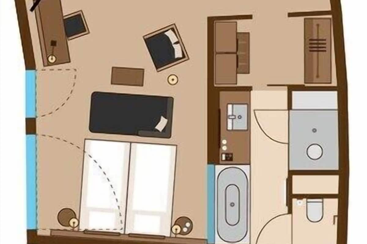 Une pièce comprenant un lit, un bureau, une chaise, une armoire, une salle de bain et un petit coin cuisine.