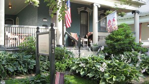 Een huis met een veranda, een brievenbus en een Amerikaanse vlag.