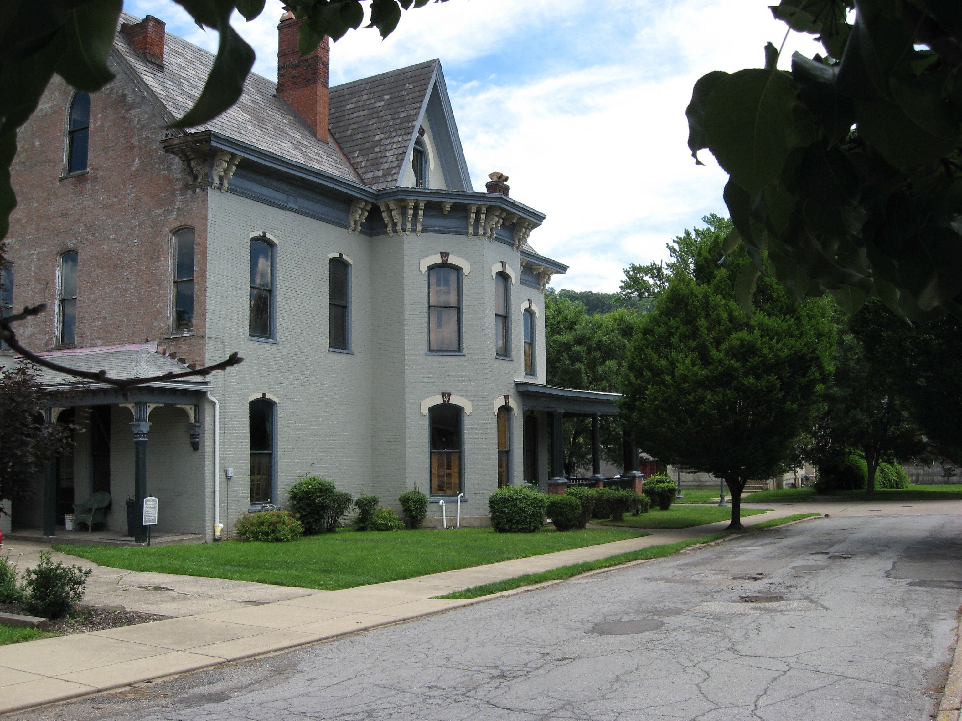 A historic two-story building with a prominent gabled roof and a large front porch.