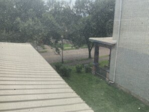 Une chambre dotée d’une grande fenêtre, d’un lit et donnant sur un jardin.