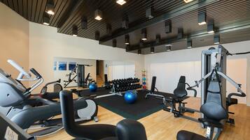 Un gimnasio con equipo de cardio, máquinas de pesas y pesas libres.