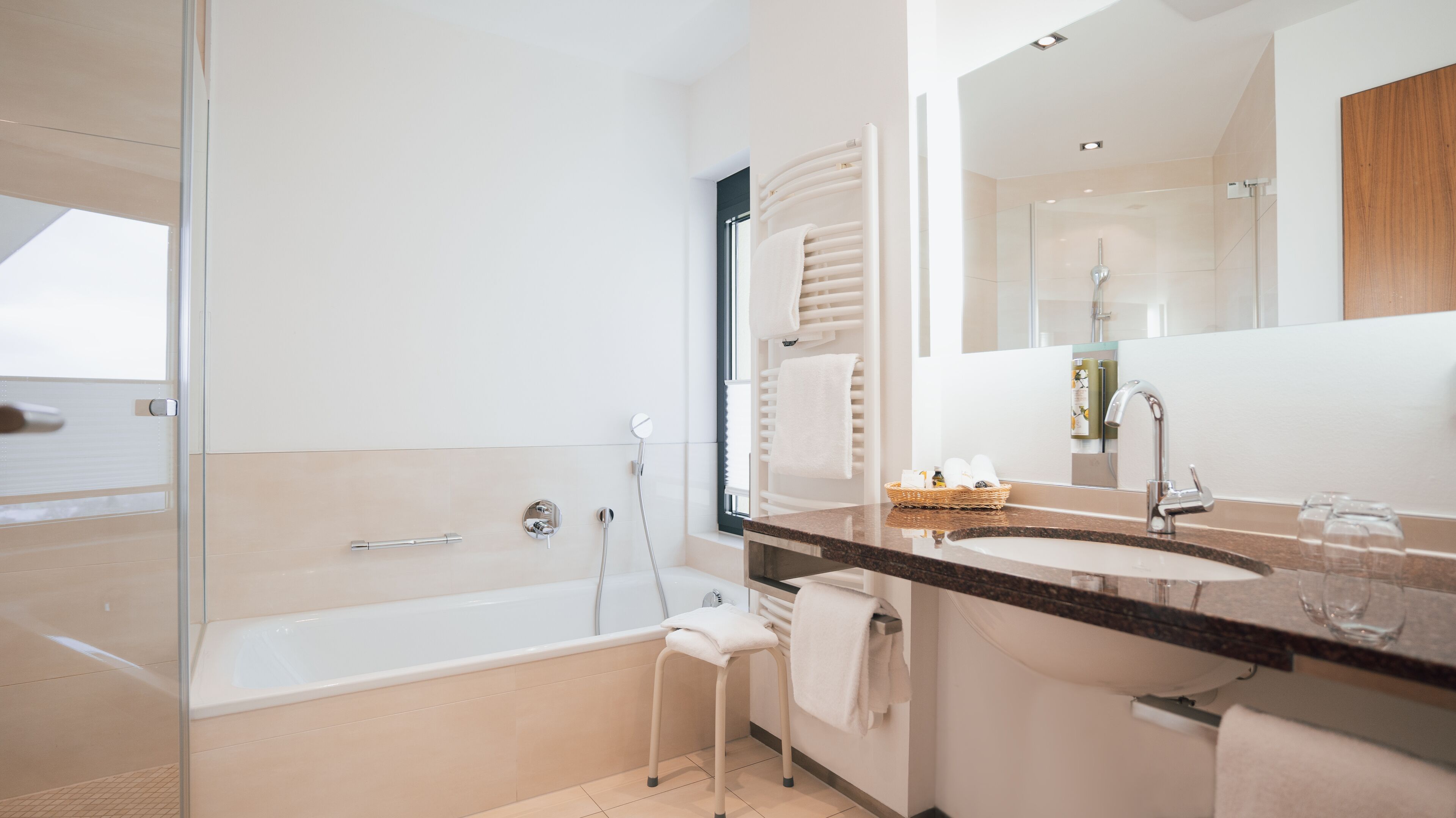 A modern bathroom with a bathtub, a sink, and a shower.