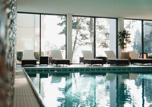 Una piscina techada, sillones reclinables de piscina