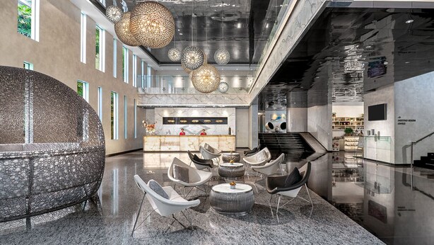 Una hall moderna con reception, area salotto e una scala.