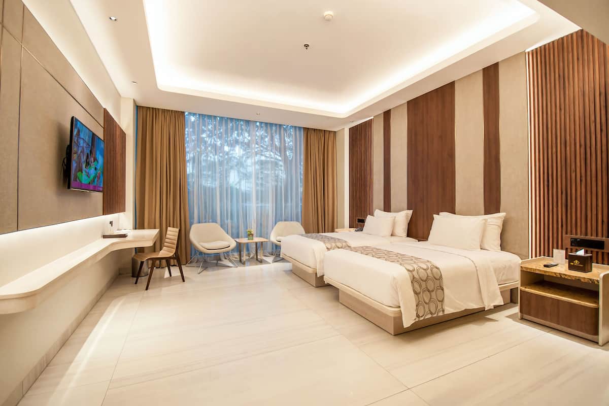 A modern hotel room with a large bed, a desk, and a TV.